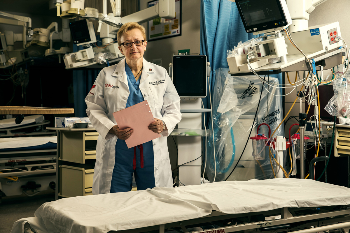 Deborah Kuhls is dressed in surgical scrubs and a white coat in a Las Vegas hospital's trauma room
